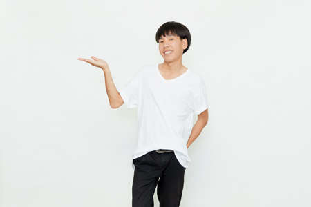Portrait of an attractive young Asian man in casual white t-shirt doing open hand gesture  isolated on white backgroundの写真素材