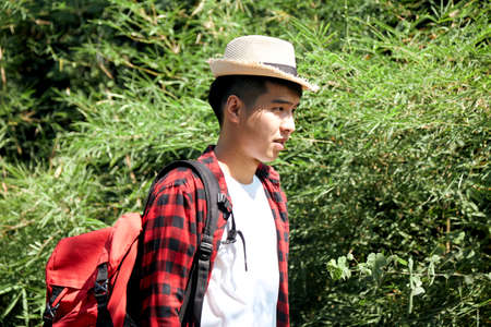 Young hipster Asian man traveling with a backpack in summer forest trip travel lifestyle conceptの写真素材