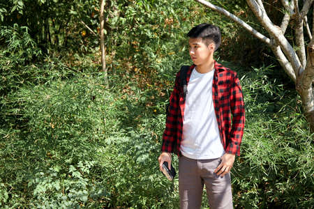 Young hipster Asian man traveling with a backpack in summer forest trip travel lifestyle conceptの写真素材