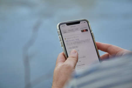 Closeup of men hands holding and touching a smartphoneの写真素材