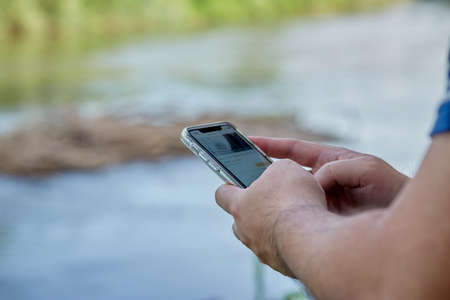 Closeup of men hands holding and touching a smartphoneの写真素材