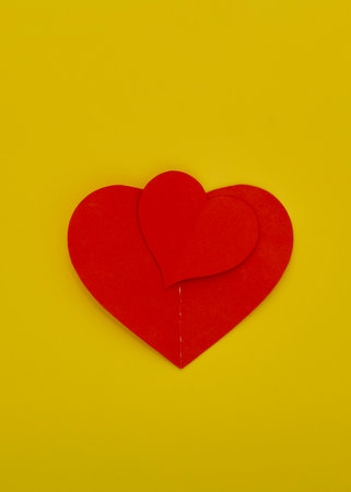 Top view Paper valentines day red hearts on a yellow background Concept for love copy space for textの写真素材