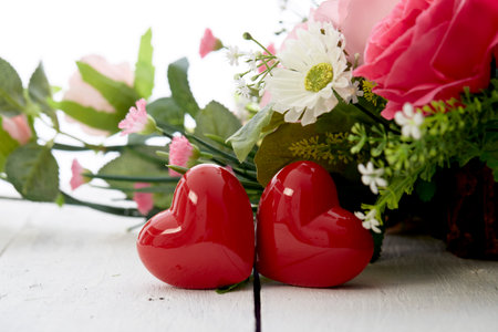 Valentin day romantic red heart and  colorful flowers bouquet on white wooden tableの写真素材