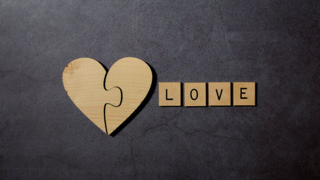 Love text word wood blocks withe wooden Heart on the Black cement floor Valentine's Day Minimal concept top viewの写真素材