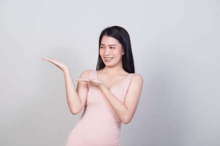 Beautiful young Asian woman smiling portrait a girl with wear pink dress have a fun and happy of positive with success isolated on white background, female health model concept.の写真素材