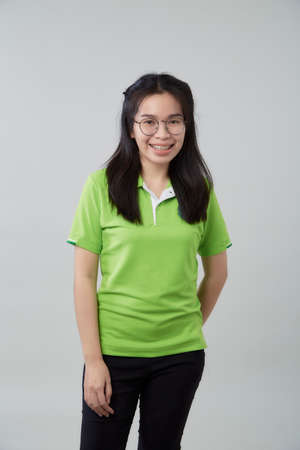 Happy young Asian woman portrait with a green shirt gray background, beautiful Asian confidence teenagerの写真素材