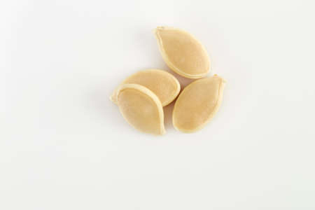 Pile of raw pumpkin seeds on white background