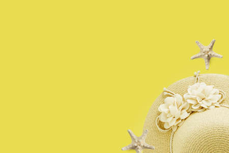 Beautiful summer holiday background with some accessories hat and shells on  yellow wood panel, top...
