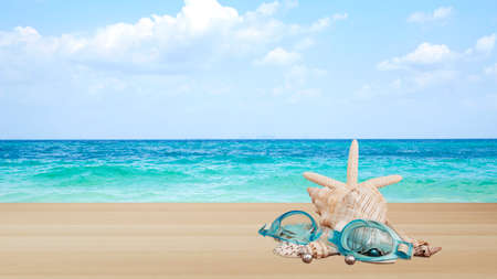 Swimming goggles with shells, wood brown color texture with a beautiful nature blur ocean backdrop used for display or montage your productsの写真素材