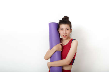 exercise fitness Thai Asian woman ready for workout standing holding yoga mat on white background