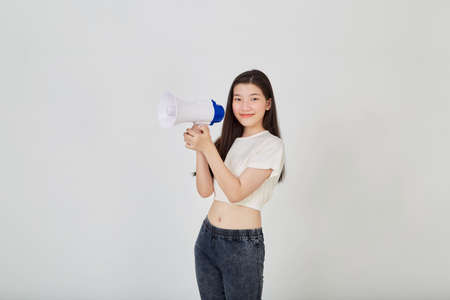 Portrait beautiful young asian woman smile with megaphone making announcement in isolated studioの写真素材