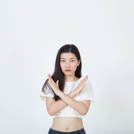 Angry serious woman with brunette hair showing crossed hands gesture isolated white background, showing stop gestureの写真素材