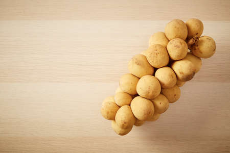 Top view Group of Longkong is fruit southern Asian Thai on the wooden table copy space for textの写真素材