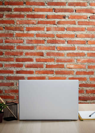 spooky Halloween pumpkin, Jack O Lantern on a wooden bench table, and brick wall copy space for textの写真素材