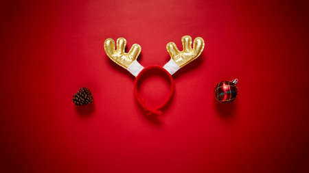 Funny Santa reindeer headband horns isolated on a red background. Top view with copy space. Holiday...