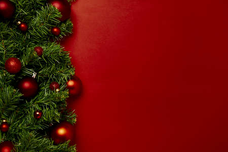 Red Christmas baubles decoration on red background with copy space