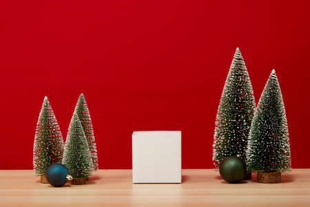 Christmas tree composition gift box Christmas baubles on a wooden table wall red background. for new year or Merry christmas holidays of free space for your decoration Copy space for your textの写真素材