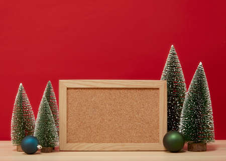 Empty Wooden board with Christmas pines on a wooden table wall red background of free space for your decoration Copy space for your textの写真素材