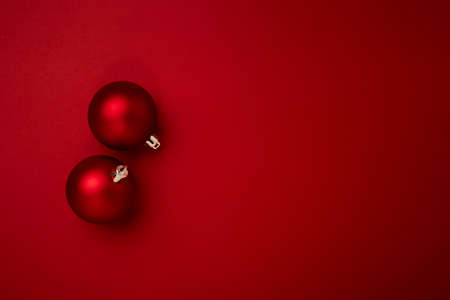 Red Christmas ball decoration on red background with copy space. New Year greeting card. Minimal styleの写真素材