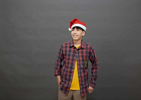 Young Asian man wearing christmas hat on studio shot, Isolated on gray backgroundの写真素材