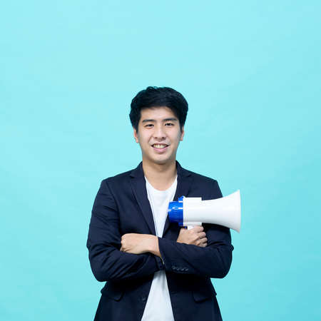 Asian businessman holding megaphone isolated on light blue background