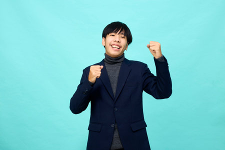 young Southeast Asian man with happy and self-confident positive expression with crossed arms in light blue studio isolated backgroundの写真素材