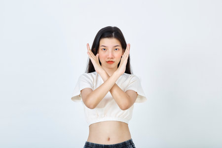 Beautiful young Asian woman Break the bias symbol of woman's international day. Crossed handsの写真素材