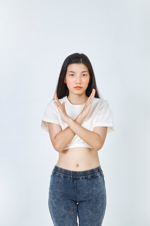 Beautiful young Asian woman Break the bias symbol of woman's international day. Crossed handsの写真素材