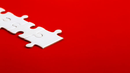 White blank puzzle pieces on a red background Merge different elements into a whole strategy and solution business conceptの写真素材
