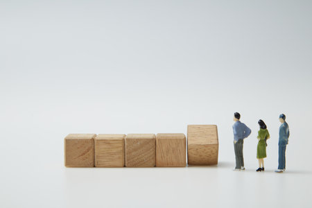 Businessman miniature people figure and wooden cubes in a row. Blank wooden blocks for words, text, or illustrations on a white background are used to create text or symbols. growth success.の写真素材