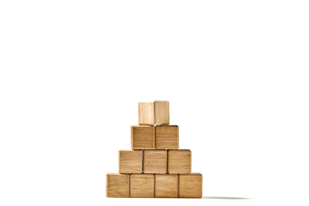 Close-up wood cubes arranges in a pyramid shape mock-up for creating symbols or logos, business growth, and management concept on white backgroundの写真素材