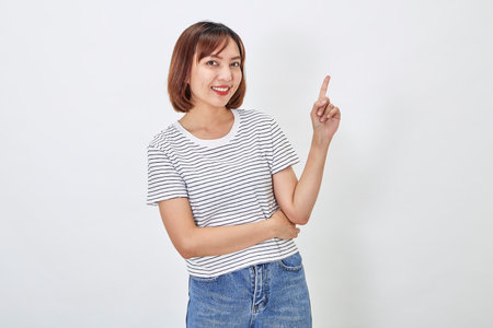 Attractive Asian woman in a casual t-shirt and blue jeans with action person white background. Copy spaceの写真素材