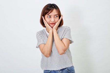 Attractive Asian woman in a casual t-shirt and blue jeans with action person white background. Copy spaceの写真素材