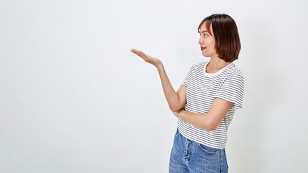 Attractive Asian woman in a casual t-shirt and blue jeans with action person white background. Copy spaceの写真素材