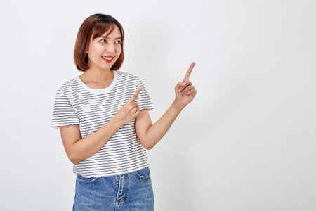 Attractive Asian woman in a casual t-shirt and blue jeans with action person white background. Copy spaceの写真素材