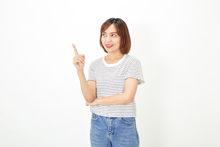 Charming young Asian businesswoman with a short brunette wearing a t-shirt and jeans standing on a white background copy spaceの写真素材