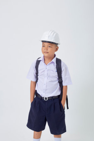 A young Asian cute boy standing in a Thai school uniform with a backpack bag and safety helmet  on a white background banner. Back to schoolの写真素材
