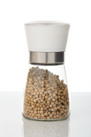 White pepper in a glass jar on white backgroundの写真素材