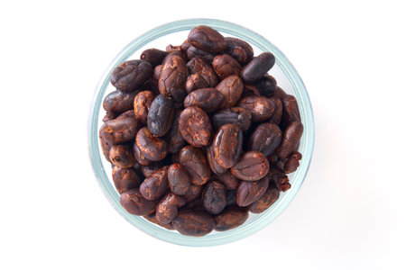 Close up Roasted cocoa beans in a glass bowl on white backgroundの写真素材