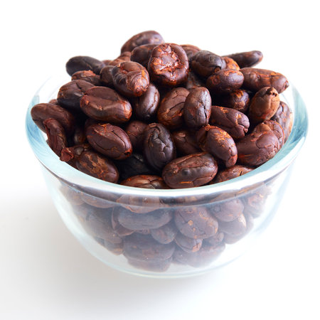 Close up Roasted cocoa beans in a glass bowl on white backgroundの写真素材