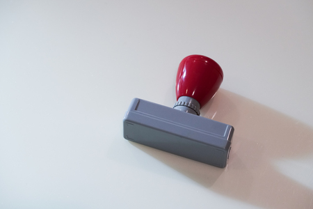 Ready to use rubber stamp with ink inside. With cover and red handle. Stamp is putting on the white creamy marble table. Copy space on the left.の写真素材
