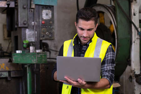 Confident of engineer or manager worker wearing a safety jacket and using a laptop to control...