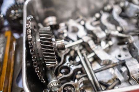 The mechanical guy removes the gear part from the diesel engine box and puts on the plate with other...