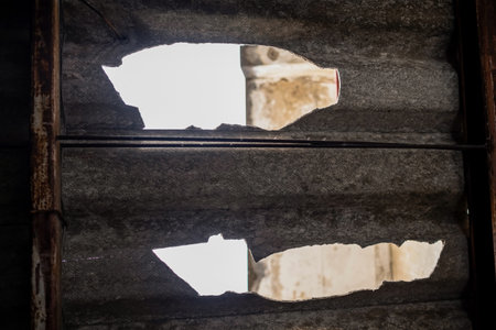 Hold on the roof after rain storm in the abandoned house. Damaged of old double cement roof and...