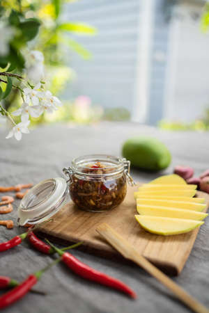 Raw green mango slice with sweet fish sauce on the wooden plate with copy space. Special ingredient, red chili, onion, shrimp, fish sauce, sugar and shrimp paste. Thailand fruit season.  Asia styleの写真素材