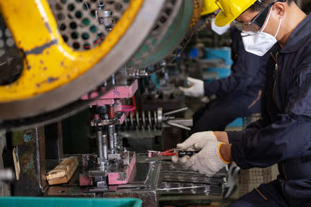 Engineer man wearing safety glass and hygiene mask working in the CNC metal factory. Selective focus...