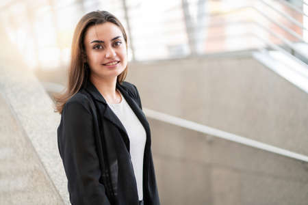 Portrait of confident businesswoman wearing suit standing outside office in the central city and...