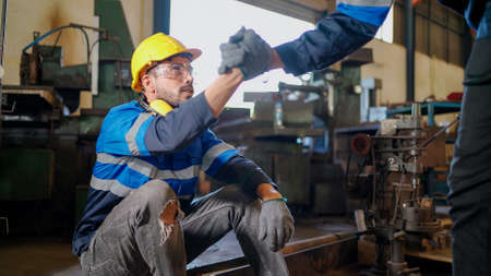 Engineer wearing safety helmet and glasses sitting and rest in the production line in factory. Boss...
