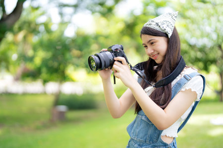 Pretty attractive girl standing in the public garden looking at camera to see the picture with copy space on sunny day. Happiness during vacation. Relaxation, Aromatherapy freedom feeling lifestyleの写真素材