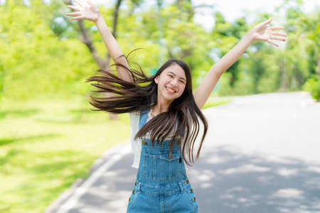 Pretty attractive girl walking and smile with many action in the garden with blur greenery background on sunny day. Happiness during vacation. Relaxation, Aromatherapy freedom feeling lifestyleの写真素材